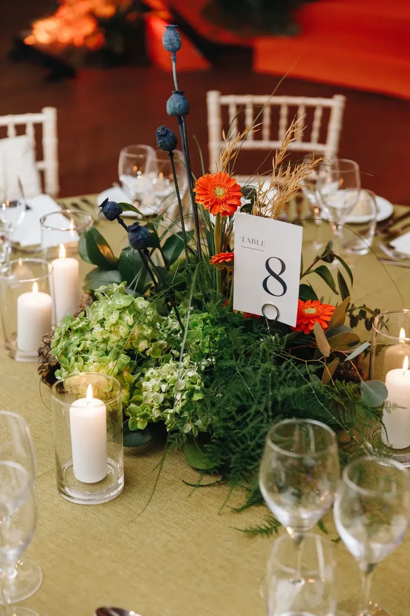 Centro de mesa floral com velas e mesa posta ao pormenor num jantar de gala produzido pela BTQ