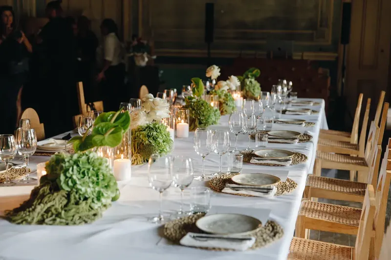 Mesa posta à luz de velas no jantar de gala L'Oréal, com centros de mesa botânicos