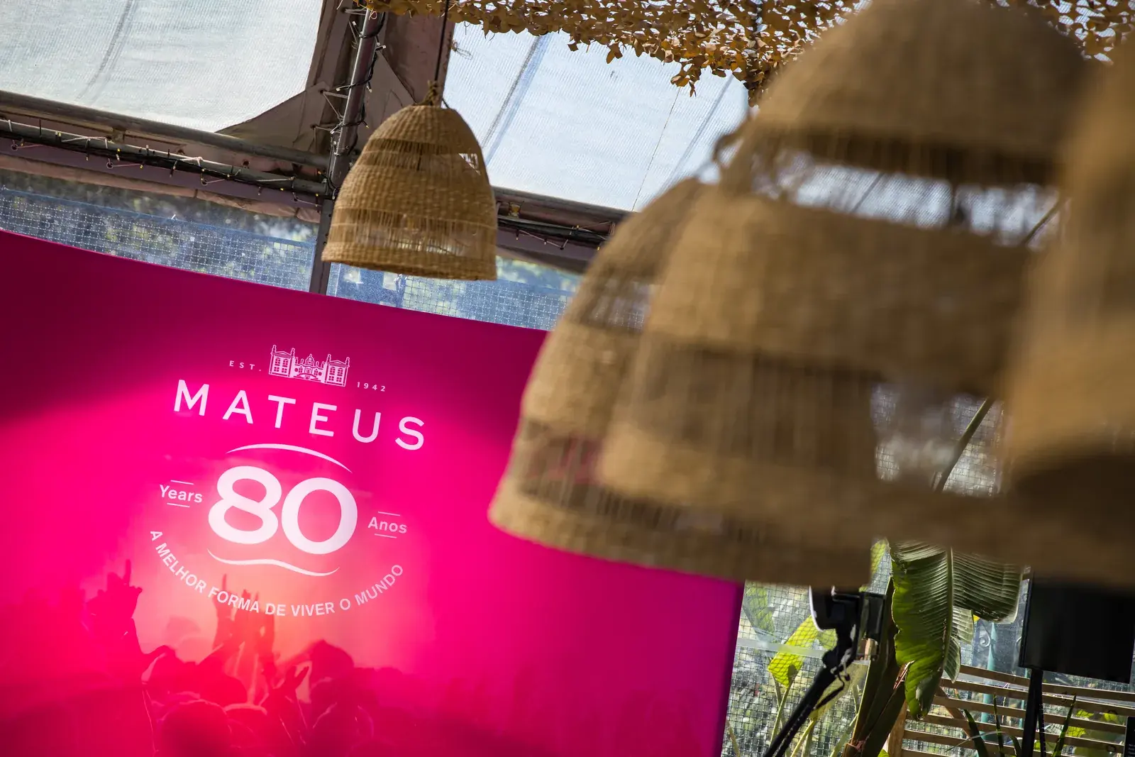 Mateus 80 Anos, uma produção de aniversário de marca em registo de festa, com bar de néon e palco de parede verde, produzida pela BTQ Events