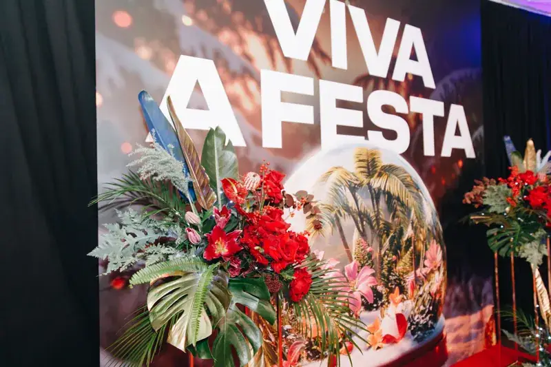 Parede «Viva a Festa» com composição floral numa festa de Natal de empresa