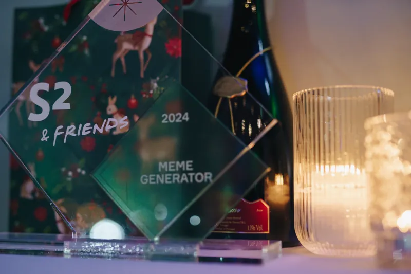 Troféu de vidro junto a uma vela numa mesa de jantar