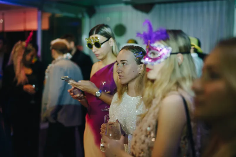 Convidadas com máscaras venezianas numa festa de empresa