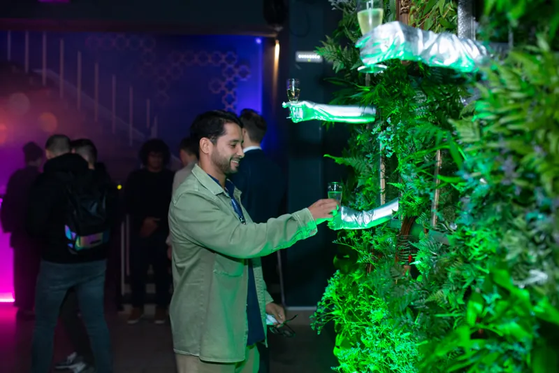 Convidado junto a uma parede verde com iluminação de néon