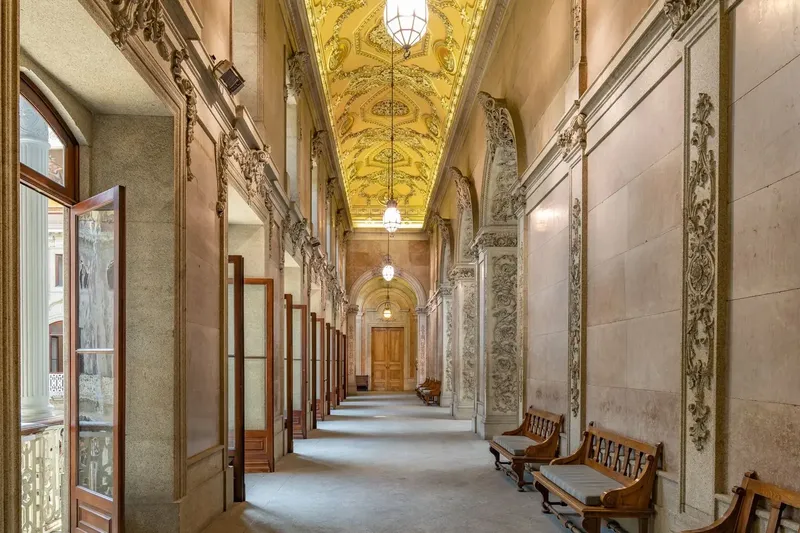 Second-floor Claustros at Palácio da Bolsa, showing the atmospheric upper-level cloister gallery used by BTQ Events as a mezzanine reception breakout space during corporate gala production