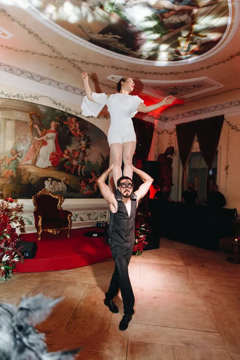Artistas de adágio aéreo a atuar sob a cúpula com frescos do Palácio do Grilo