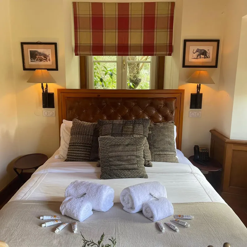 Quarto-suite na Quinta da Bella Vista com cabeceira de xadrez escocês e dois candeeiros