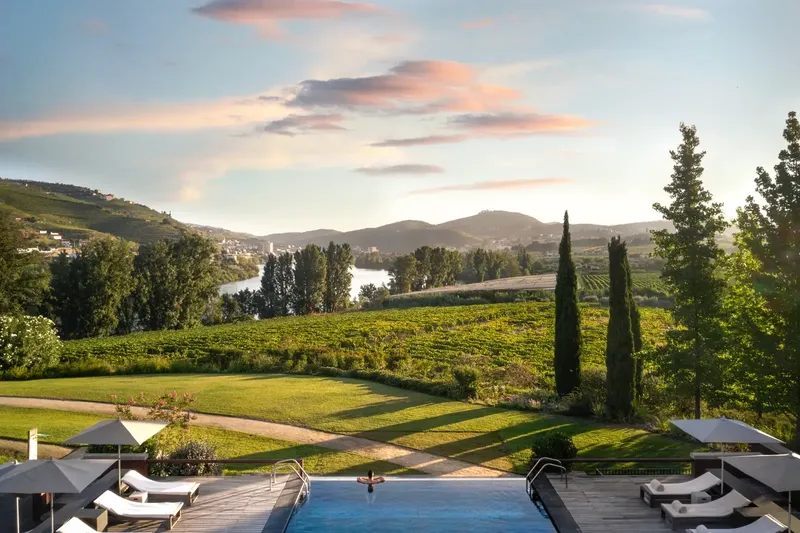 Six Senses Douro Valley outdoor pool overlooking the Douro river · golden-hour cocktail anchor