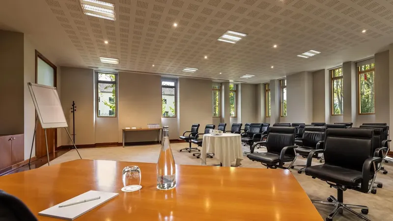 Sala de reunião do centro de conferências do Vidago Palace, em disposição de oficina e com luz natural