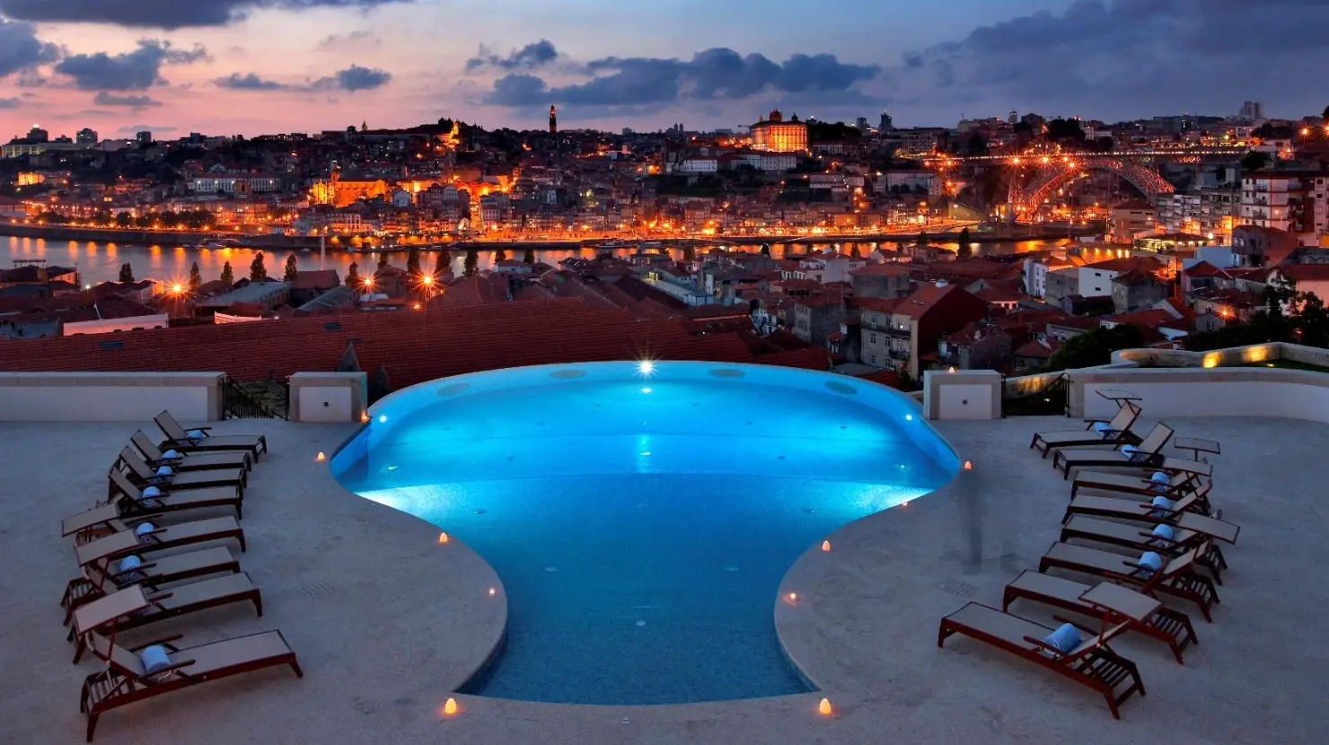 The Yeatman aerial at twilight, with a decanter-shaped infinity pool, Vila Nova de Gaia rooftops and the Douro line opposite Porto's Ribeira, the south-bank wine hotel produced by BTQ Events for corporate galas